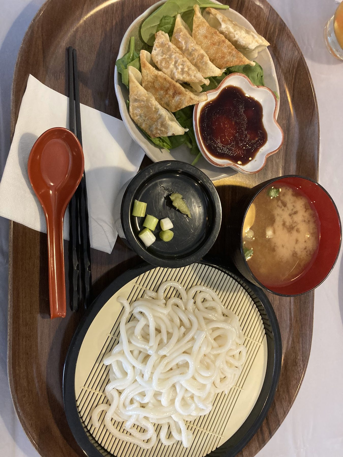 A set with udon noodles, gyoza, dipping sauce and miso soup