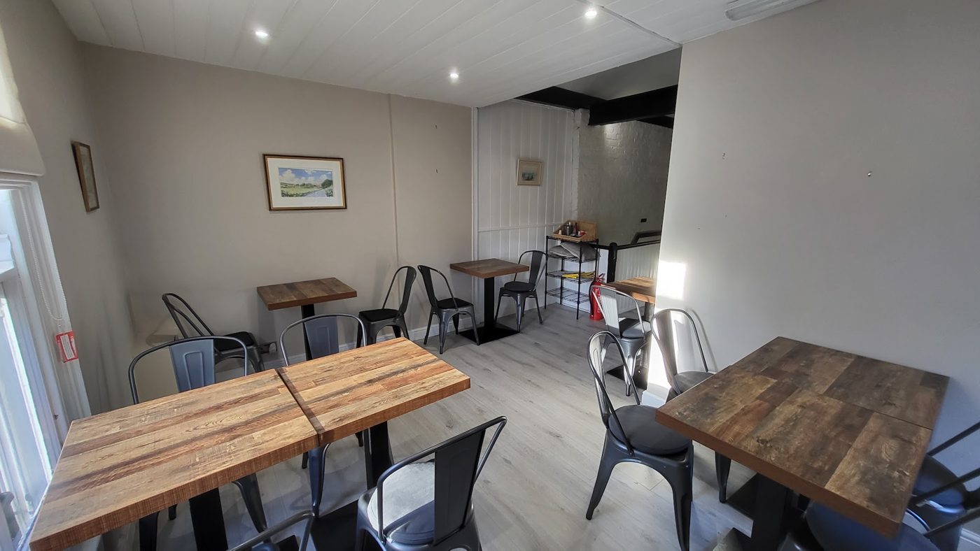 Wooden tables and grey chairs by the window